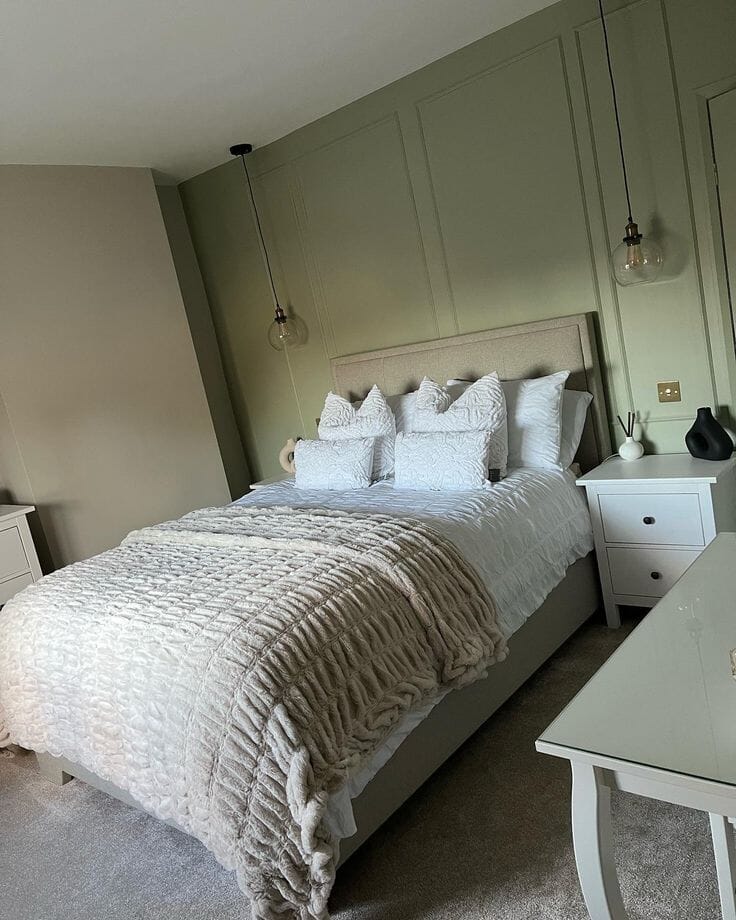 Grey bed on green panelled wall