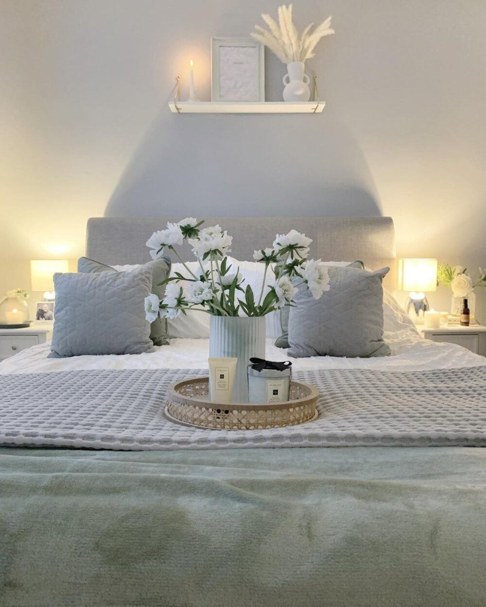 Bed dressed in white bedding and cushions